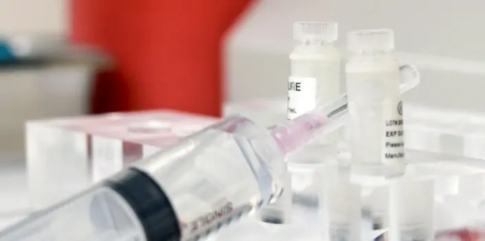 A syringe sits between 2 vials of Mesenchymal Stem Cells.