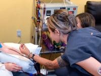 Two nurses monitoring the patient and the EBOO (Extracorporeal Blood Ozonation) system during treatment.