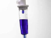 Methylene Blue solution visible inside the IV drip chamber before patient treatment infusion.