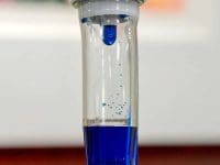 Methylene Blue intravenous solution dripping into the IV chamber for Long COVID treatment.