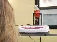 A nurse closely monitoring the 10-Pass Ozone Therapy (Hyperbaric MAH) blood ozonation device.