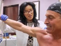 Dr. Alice Pien, MD, performs a range of motion check on patient Scott's arm following a prolozone joint injection.