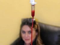 Blood dripping in the chamber during Single-Pass Ozone Therapy (MAH) with a smiling patient out of focus.