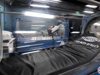 Wide view of a vaccine-injured patient receiving treatment inside a hyperbaric oxygen therapy (HBOT) chamber.